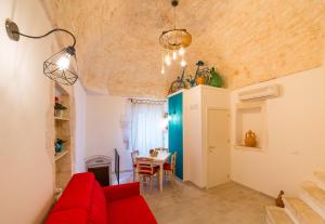 een woonkamer met een rode bank en een tafel bij Arcuève-Dimora con vista CON TERRAZZE PANORAMICHE in Ostuni