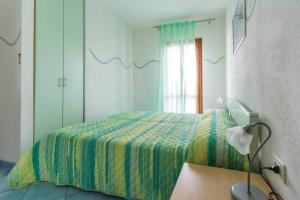 サンタ・テレーザ・ガッルーラにあるResidenza Luciaのベッドルーム(ベッド1台、ランプ、鏡付)