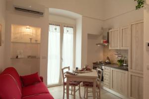 een keuken en een woonkamer met een rode bank en een tafel bij Palazzo Rattazzi in Monopoli