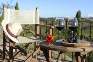 a table with two glasses of wine and a plate of grapes at Agriturismo Corte in Poggio in Stabbia
