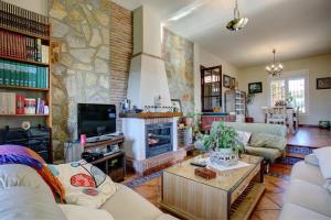 sala de estar con chimenea y pared de piedra en Los Picachos 10, en Ronda