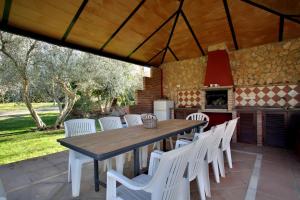Una mesa de madera y sillas blancas en un patio. en Los Picachos 10, en Ronda
