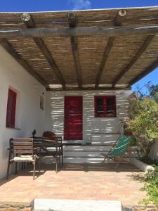 a patio with a table and chairs under a wooden roof at Casa Pedralva in Vila do Bispo