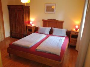 1 dormitorio con 1 cama grande y 2 mesitas de noche en Ferienwohnungen Bistro Tebecks en Wadern