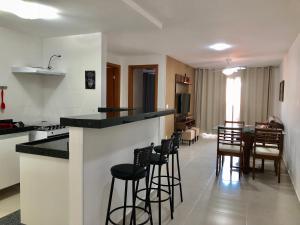 cocina y sala de estar con bar y sillas en Apto no Le Bon Vivant Praia Grande, en Arraial do Cabo