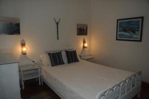 ポルト・サントにあるCharming Villa at the beachのベッドルーム1室(白いベッド1台、ランプ2つ、テーブル2台付)
