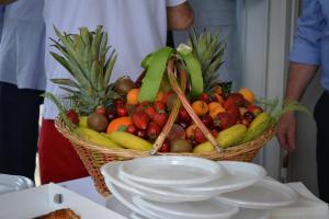 a basket of fruit on a table with plates at Hotel Noto Marina Stella Marina - B&B in Noto Marina