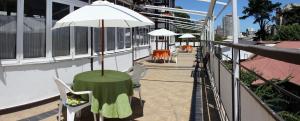 ein Tisch mit Sonnenschirm auf einem Balkon in der Unterkunft Hotel Chalet Suizo in Viña del Mar + 19 Fotos