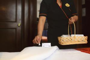 a woman is making a pillow on a bed at Hotel Ciros in Pachuca de Soto