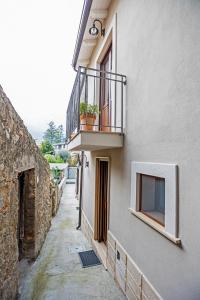 a narrow alley with a balcony and a window at B&B Acquachiara in Roccella Ionica