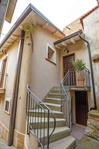 a building with stairs and a door with a plant at B&B Acquachiara in Roccella Ionica