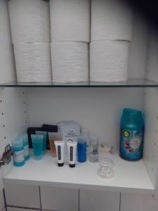 a shelf with rolls of toilet paper and other toiletries at City Apartment in Aarhus