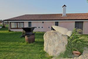 a large rock sitting in front of a house at Agriturismo Sa Ruda in Càbras