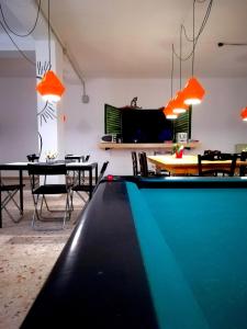 a room with a pool table and a dining room at Dimora Hostel in Agrigento