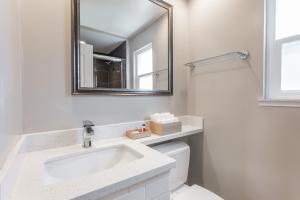 Baño blanco con lavabo y espejo en Sather Berkeley - SureStay Collection by Best Western, en Berkeley