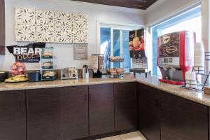 cocina con armarios marrones y encimera en Sather Berkeley - SureStay Collection by Best Western, en Berkeley