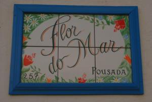 een bord voor een bloemenwinkel in een blauw frame bij Pousada Flor do Mar in Paraty