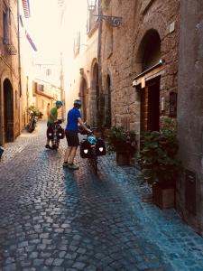 two people on motorcycles on a cobblestone street at B&B La Casa Di Tufo in Orvieto