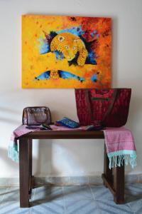 a table with a painting on the wall at Balamku Hotel Petit in Campeche