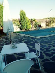 une terrasse avec une table, des chaises et un parasol dans l'établissement Alondra, à Olías del Rey