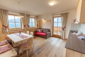 a kitchen and living room with a table and a couch at Egarterhof in San Candido