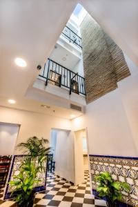 un vestíbulo con suelo a cuadros y dos plantas en Hostel A2C en Sevilla