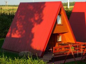 ein orangefarbenes und rotes überdachtes Haus mit einer Veranda in der Unterkunft 7 Dziewczyn in Dźwirzyno