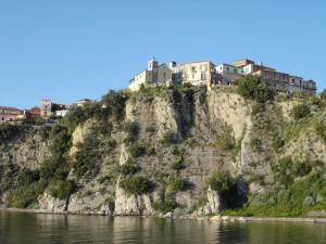 a house on top of a hill next to the water at Casa Le Querce in Ogliastro Cilento