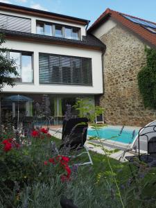 ein Haus mit Pool und Stühlen im Hof in der Unterkunft Gästehaus Haiminger ehemalig Schmelz in Weissenkirchen in der Wachau