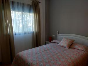 1 dormitorio con cama con almohada y ventana en Apartamento Granada Monachil I, en Monachil
