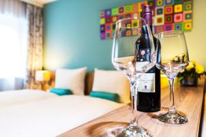 eine Flasche Wein und zwei Gläser auf dem Tisch in der Unterkunft das MAX Appartementhaus in Bad Wörishofen
