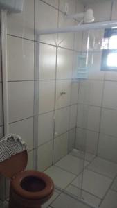 ein Badezimmer mit Glasdusche und Toilette in der Unterkunft Casa na Praia - Uma quadra do mar in Itapoa