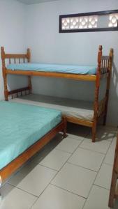 zwei Etagenbetten in einem Zimmer mit Fenster in der Unterkunft Casa na Praia - Uma quadra do mar in Itapoa