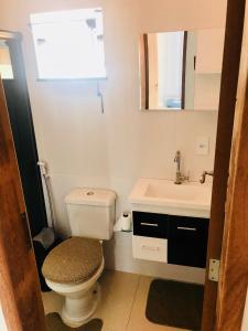 a bathroom with a toilet and a sink at Apartamentos da praia in Arraial do Cabo