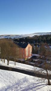a snow covered field with a building in the distance at Fewo Bergblick in Kurort Oberwiesenthal