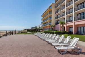 a row of white chairs sitting in front of a building at Wyndham Virginia Beach Oceanfront in Virginia Beach
