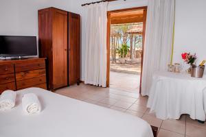 a bedroom with two beds and a tv and a window at Villa del Mar Praia Hotel in Camocim +45 photos