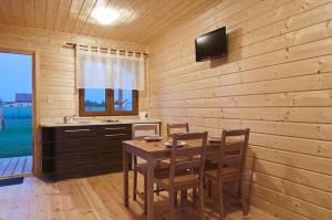 a dining room with a table and chairs and a television at Delfinek in Darłowo