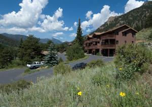 a house on the side of a road next to a mountain at Wildwood Inn in Estes Park