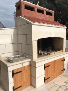 un horno de pizza al aire libre con chimenea de ladrillo en la parte superior en Apartments Maričević en Korčula