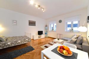 a living room with a couch and a table with a bowl of fruit at Block Apartment Upper Town in Zagreb
