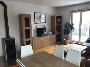 a living room with a dining room table and a television at Villa Fink in Schramberg