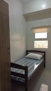 uma cama num quarto com uma janela em Jhocson Residences em Manila