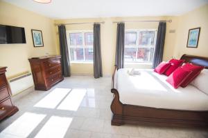 ein Schlafzimmer mit einem großen Bett mit roten Kissen in der Unterkunft The Sir John Rodgersons Suite in Dublin