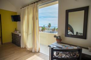 una sala de estar con una gran ventana con vistas al océano en Marisol Hotel Boutique en San José del Cabo