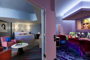 a hotel room with a bed and a couch and a table at Universal's Hard Rock Hotel® in Orlando