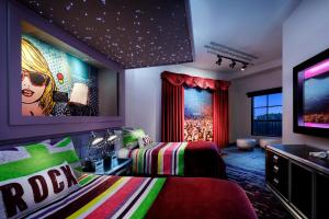 a bedroom with two beds and a flat screen tv at Universal's Hard Rock Hotel® in Orlando