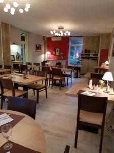 une salle à manger avec des tables et des chaises en bois et un restaurant dans l'établissement Logis hôtel restaurant les Carillons, à Cransac