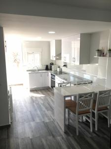 a kitchen with white cabinets and a table and chairs at Plaza Sainetero in Valencia