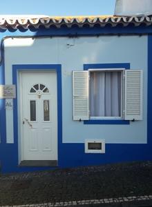 a blue building with a white door and a window at Mar de Prata in Maia